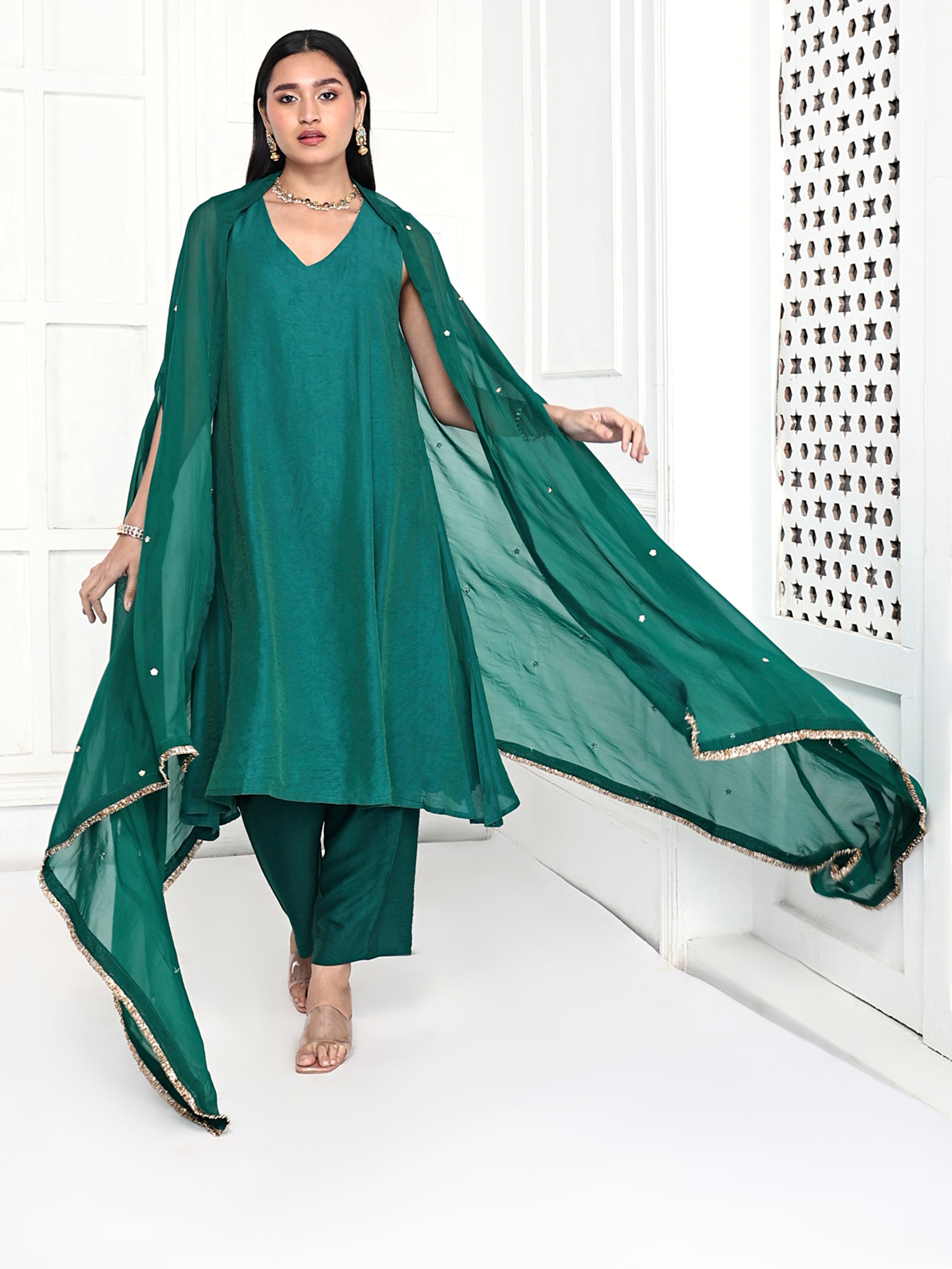 A line tunic paired with pants and embellished cape.