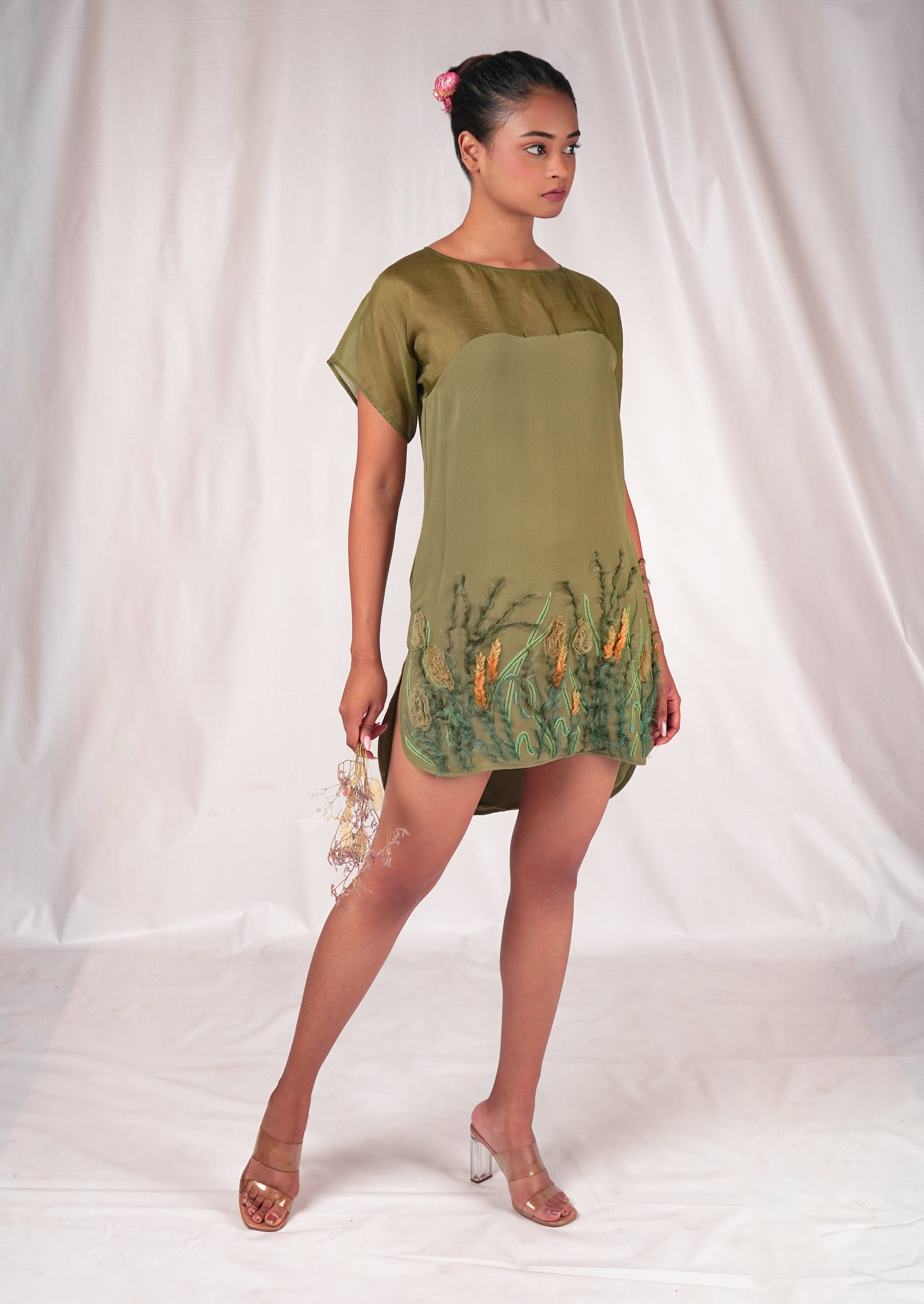 Green dress featuring floral embroidery motifs