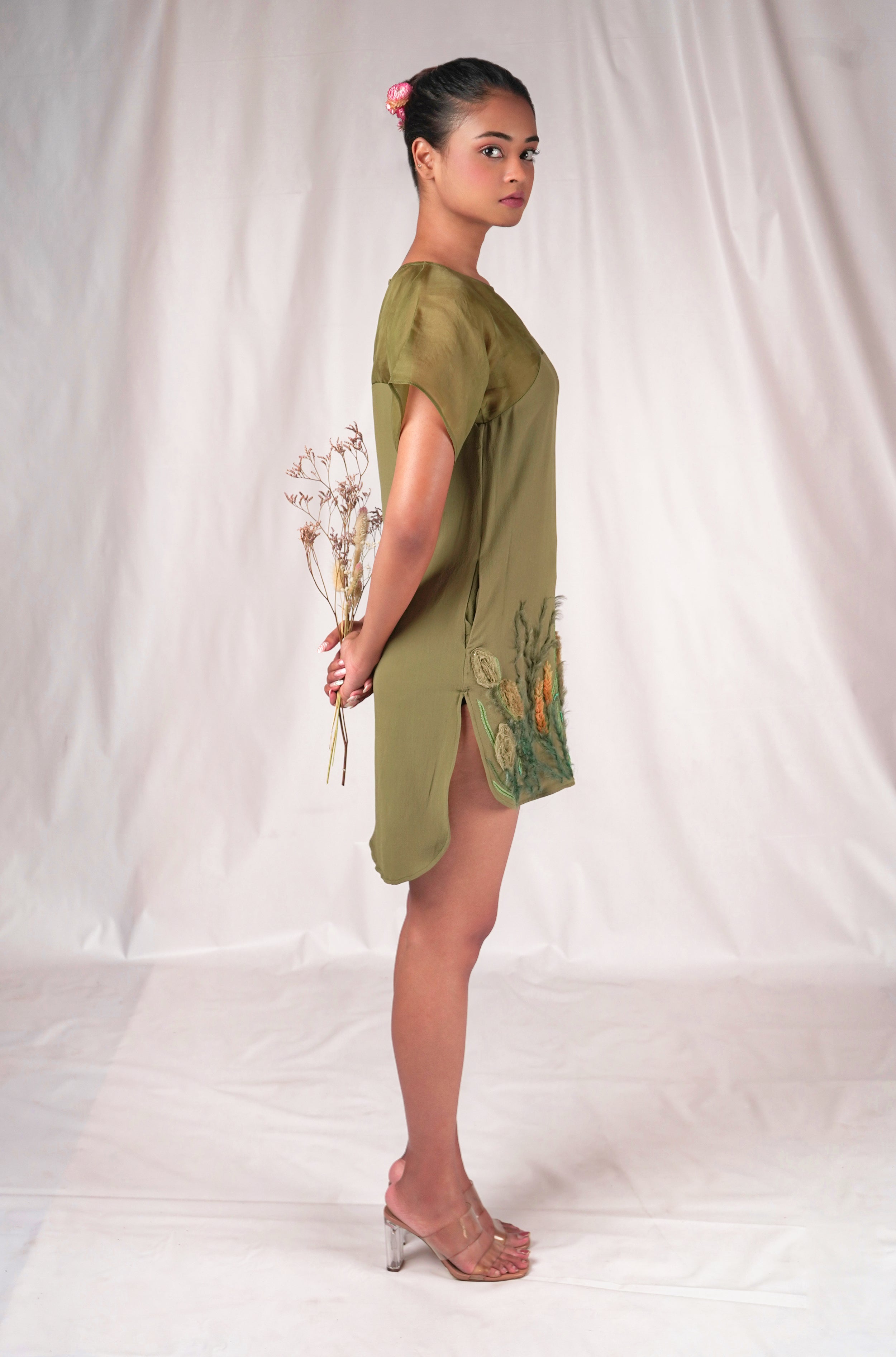 Green dress featuring floral embroidery motifs